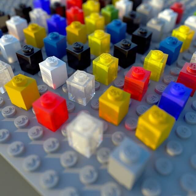 How to Achieve Artistic Talent: Are Artists Born or Made? 4 photograph of lego individual lego blocks of different colors attached to a flat grey board representing different personalities in the artistic nature vs nuture debate